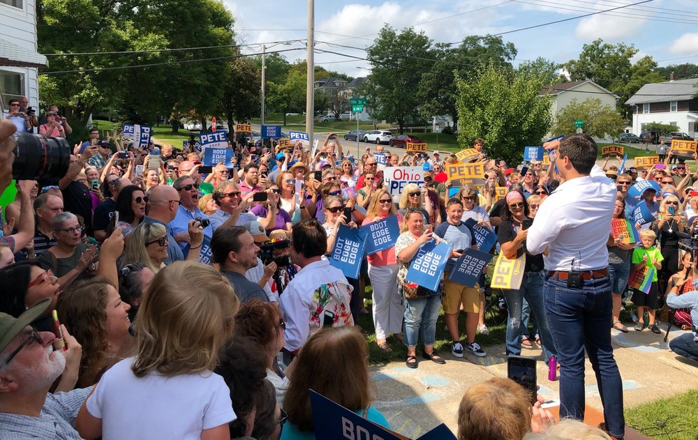 Photo posted by Dan Merica  (LINK)  with text ”Buttigieg tells the audience that “climate change is becoming a clear and present danger to our very way of life,” that the “second amendment has been twisted” and that he wants the make the presidency an “office that kids can look up to.”"